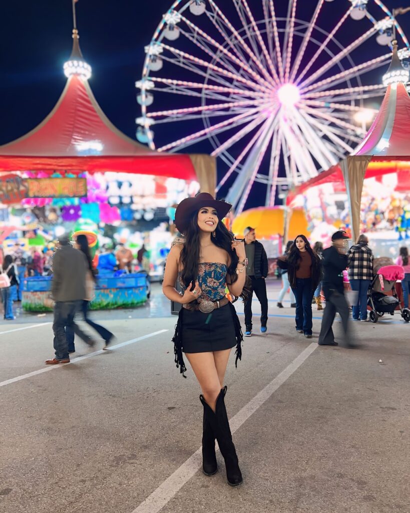 Modern Cowgirl Outfit Inspo Fun Black Jeans Skirt with Black boots and no sleeve top with a hat